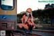 A woman in an orange jumpsuit sitting on a train track.