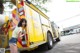 A woman standing in front of a yellow fire truck.