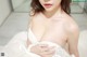 A woman in a white dress is posing for the camera.