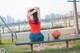 A woman sitting on a bench with a basketball.